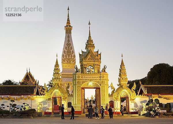 Menschen vor dem Chedi des Wat Phra That Phanom  Abenddämmerung  Tempelanlage in Amphoe That Phanom  Provinz Nakhon Phanom  Isan  Thailand  Asien