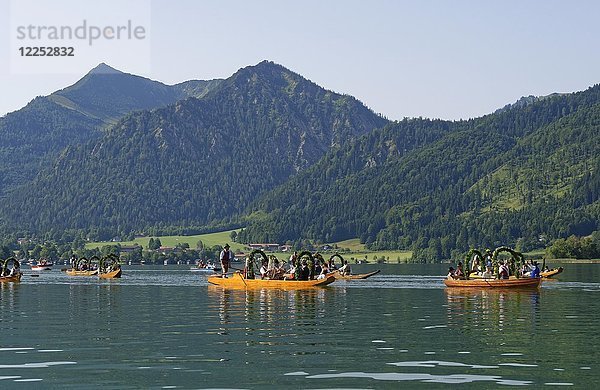 Männer in Tracht auf festlich geschmückten Plätzen  Holzboote  auf dem Schliersee  hinter Brecherspitze  Alt-Schlierseer-Kirchtag  Schliersee  Oberbayern  Bayern  Deutschland  Europa