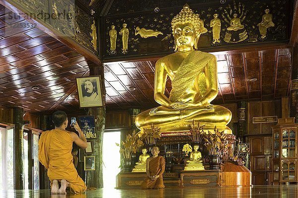 Mönche vor der goldenen Buddha-Statue  Wat Phuttha Nimit Phra Saiyat  Phra Buddha Phukhao  Bezirk Sahatsakhan  Kalasin  Isan  Thailand  Asien