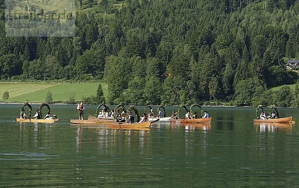 Trachtentragende Männer auf festlich geschmückten Plätzen  Holzboote  auf dem Schliersee  Alt-Schlierseer-Kirchtag  Schliersee  Oberbayern  Bayern  Deutschland  Europa