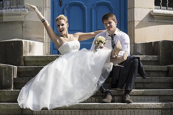 Junges Brautpaar sitzt auf einer Treppe und posiert glücklich  Schweiz  Europa