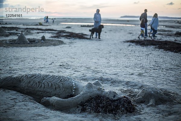 Meerjungfrau aus Sand und Spaziergänger in der Abenddämmerung am Strand  Portbail  Cotentin  la Manche  Normandie  Frankreich  Europa
