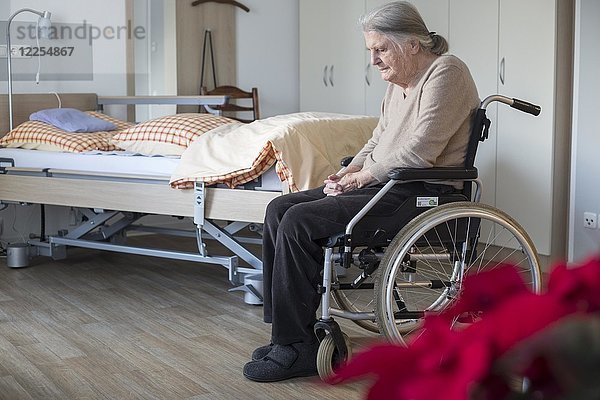 Demenzkranke Seniorin im Rollstuhl allein in ihrem Zimmer in einem Pflegeheim  Köln  Nordrhein-Westfalen  Deutschland  Europa