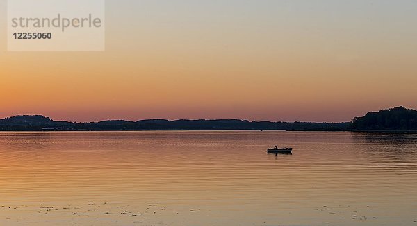 Sonnenuntergang am Chiemsee  Fischer auf einem Ruderboot  Prien  Bayern  Deutschland  Europa