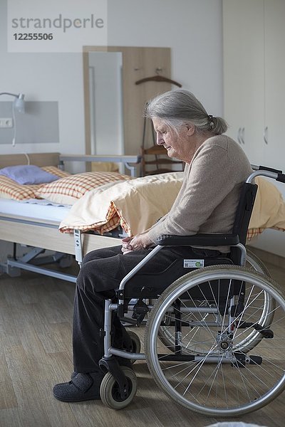Demenzkranke Seniorin im Rollstuhl allein in ihrem Zimmer in einem Pflegeheim  Köln  Nordrhein-Westfalen  Deutschland  Europa