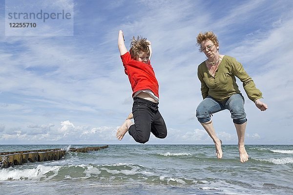 Mutter und Sohn springen am Strand  Ahrenshoop  Fischland  Mecklenburg Vorpommern  Deutschland  Europa