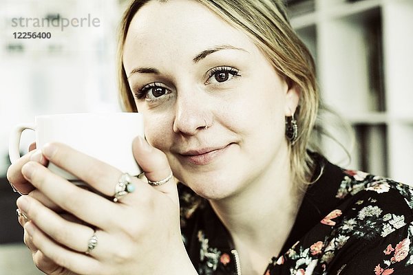 Junge Frau mit einer Tasse Kaffee in der Hand  Porträt  Deutschland  Europa