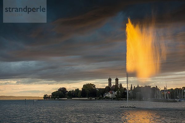 Springbrunnen und Gewitterwolken bei Sonnenuntergang  Schlosskirche im Hintergrund  Friedrichshafen  Bodensee  Baden-Württemberg  Deutschland  Europa