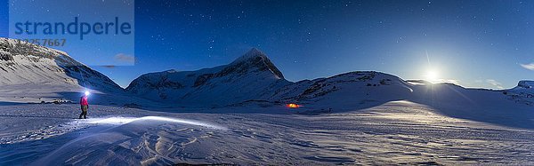 Person mit Zelt bei Vollmond im Schnee  Kungsleden oder Königsweg  Provinz Lappland  Schweden  Skandinavien  Europa