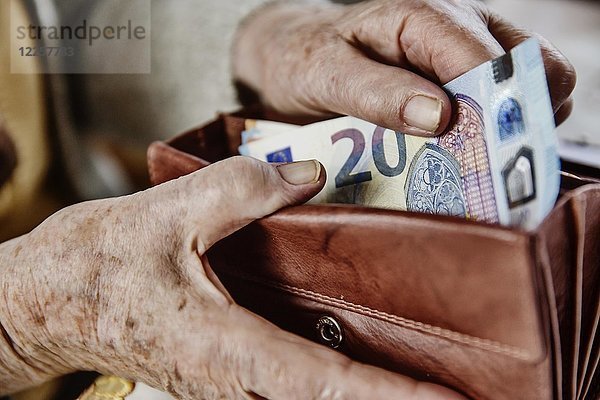 Seniorin zieht einen 20-Euro-Schein aus ihrem Portemonnaie  Deutschland  Europa