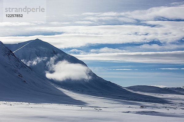 Wolke zwischen Bergen im Schnee  Tjäktja-Pass  Kungsleden oder Königsweg  Provinz Lappland  Schweden  Skandinavien  Europa