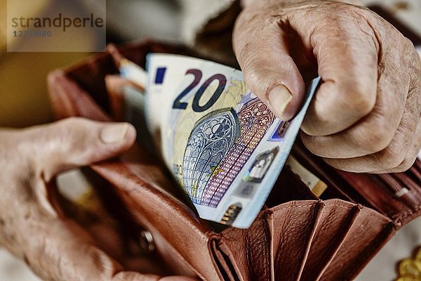 Seniorin zieht einen 20-Euro-Schein aus ihrem Portemonnaie  Deutschland  Europa