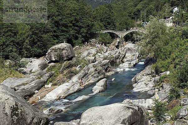Felsformationen  badende Menschen in Verzasca bei Lavertezzo  im Hintergrund die römische Brücke Ponte dei Salti  Verzascatal  Valle Verzasca  Kanton Tessin  Schweiz  Europa