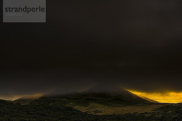 Vulkankegel in dunkler Wolkendecke mit dramatischer Beleuchtung  Insel Pico  Azoren  Portugal  Europa
