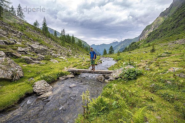 Wanderer auf einer Brücke über den Steinriesenbach  Wanderweg zur Gollinghütte  Schladminger Höhenweg  Schladminger Tauern  Schladming  Steiermark  Österreich  Europa