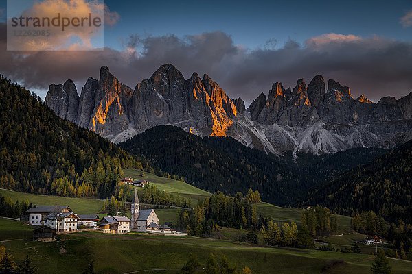Gipfel der Geislergruppe mit Dorf St. Magdalena im Herbst im Abendlicht  Villnößtal  St. Magdalena  Südtirol  Italien  Europa