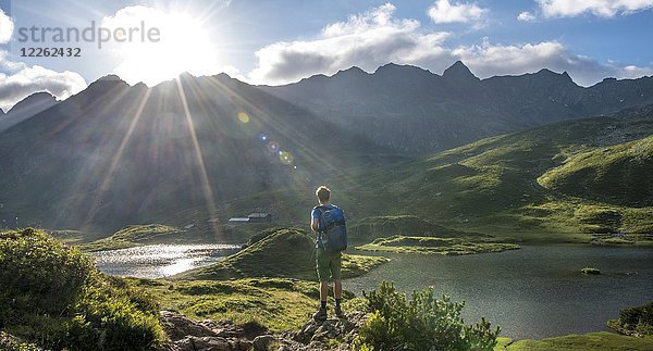 Wanderer mit Blick auf den Unteren Giglachsee bei Morgensonne  Schladminger Höhenweg  Schladminger Tauern  Schladming  Steiermark  Österreich  Europa