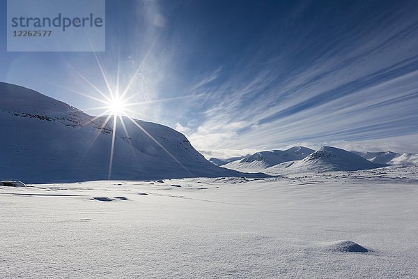 Sonne über Bergkette im Schnee  Kungsleden oder Königsweg  Provinz Lappland  Schweden  Skandinavien  Europa