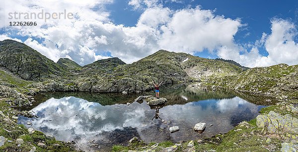 Wanderer auf einem Stein in einem kleinen See  Klafferkessel  Schladminger Höhenweg  Schladminger Tauern  Schladming  Steiermark  Österreich  Europa