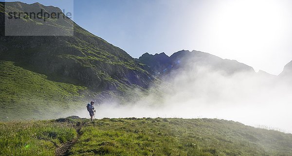 Wanderer auf dem Schladminger Höhenweg mit aufsteigenden Nebelwolken  Schladminger Tauern  Schladming  Steiermark  Österreich  Europa