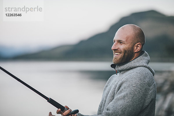 Kanada  British Columbia  glücklicher Mann beim Angeln am Kinbasket Lake