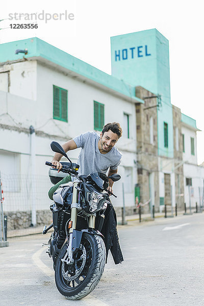 Portrait eines glücklichen jungen Mannes mit Motorrad