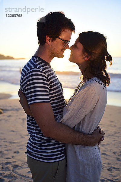Romantisches Paar am Strand bei Sonnenuntergang