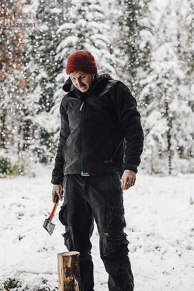 Kanada  Mann hackt Holz bei Schneefall