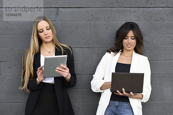 Zwei Geschäftsfrauen mit Tablett und Laptop