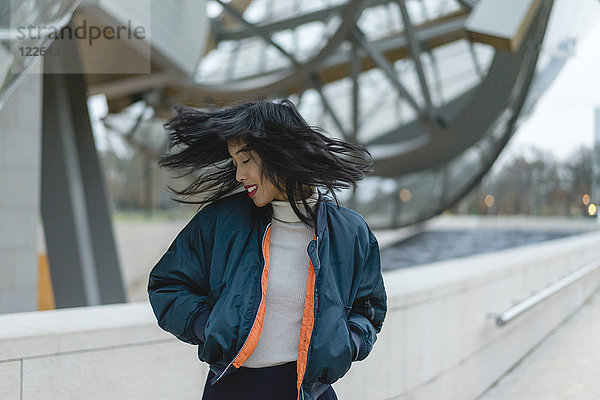 Frankreich  Paris  lächelnde junge Frau  die ihre Haare wirft