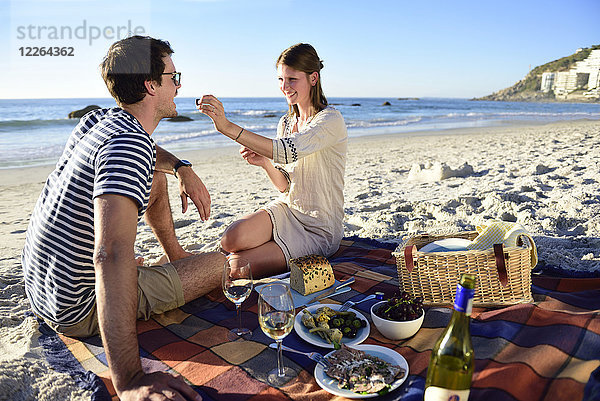 Glückliches Paar beim Picknick am Strand