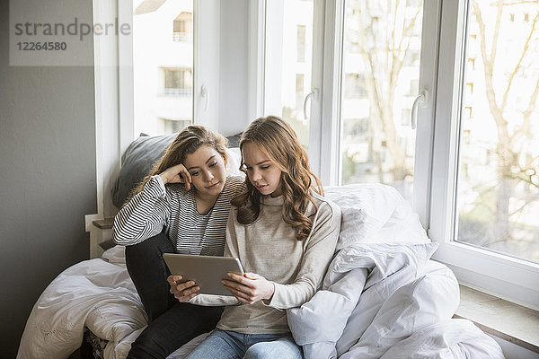 Zwei Mädchen im Teenageralter mit Tablette bei Homne
