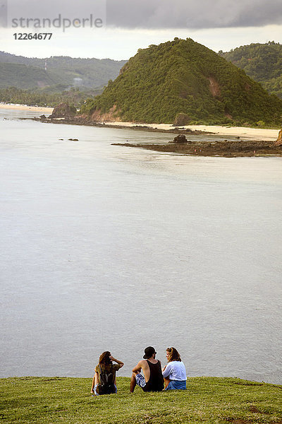 Indonesien  Lombok  Indischer Ozean  Küste  Jugendliche auf der Wiese sitzend