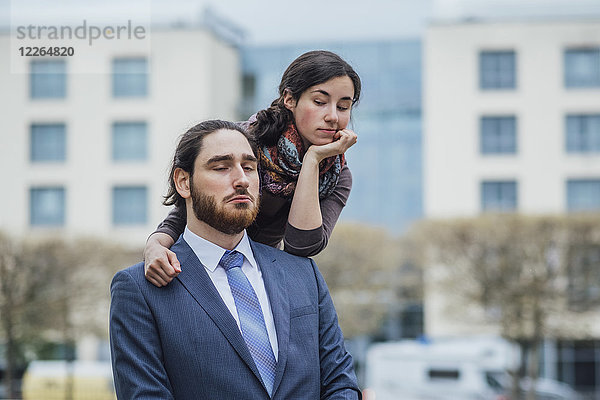 Porträt eines unzufriedenen Geschäftsmannes und einer unzufriedenen Frau vor dem Bürogebäude