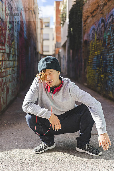 Portrait eines jungen Mannes mit Kopfhörer in Wollmütze