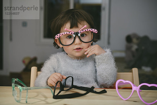 Porträt eines Mädchens  das mit einer Spielzeugbrille spielt