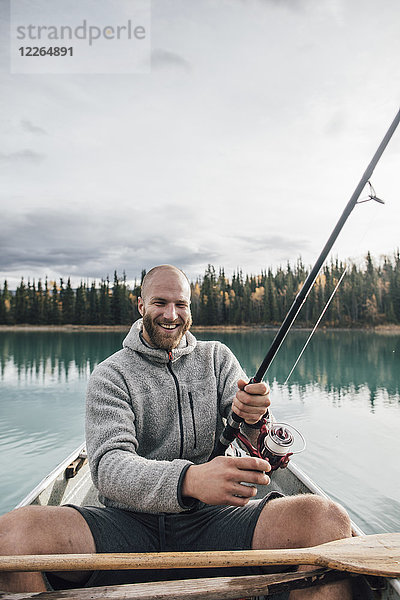 Kanada  British Columbia  Porträt des glücklichen Mannes beim Kanufischen auf dem Boya Lake