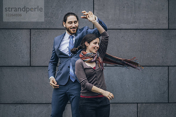Fröhlicher Geschäftsmann und Frau tanzen im Freien