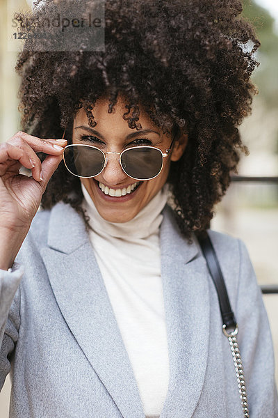 Porträt einer glücklichen Frau mit Sonnenbrille
