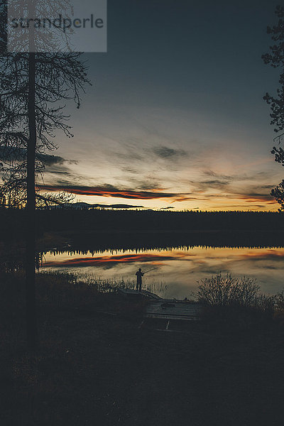 Kanada  British Columbia  Angeln am Duhu Lake bei Sonnenuntergang