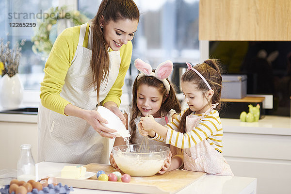 Mutter und Töchter backen gemeinsam Osterplätzchen in der Küche