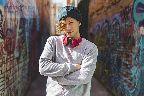 Portrait eines jungen Mannes mit Kopfhörer in Wollmütze