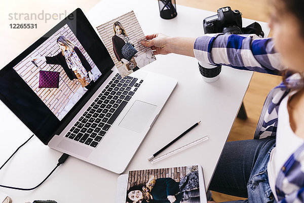 Modedesigner mit Laptop beim Betrachten von Fotos im Studio