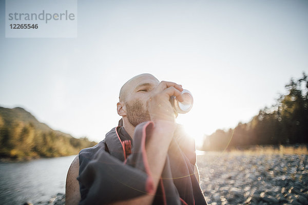 Kanada  British Columbia  Chilliwack  Mann trinkt aus der Dose am Fraser River