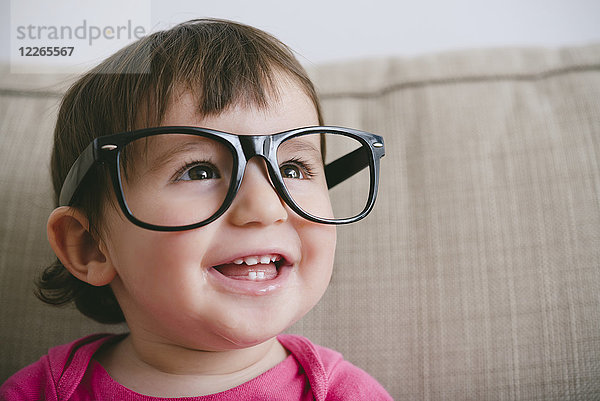 Porträt eines lachenden Mädchens mit übergroßer Brille