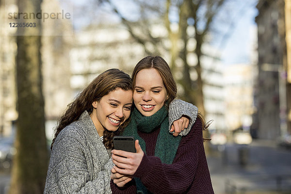 Zwei Teenager-Mädchen  die einen Selfie in der Stadt nehmen.