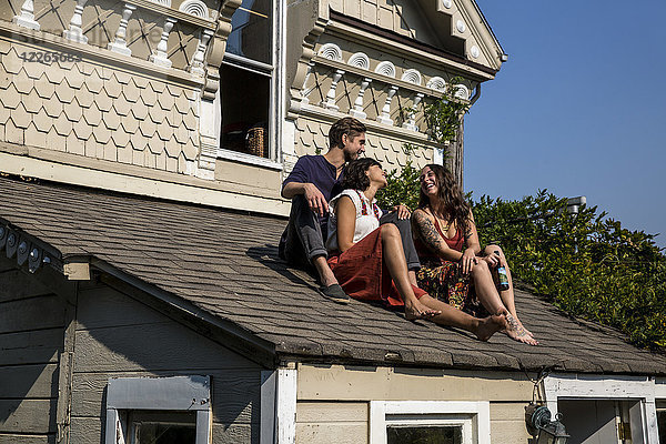 Glückliche Freunde sitzen auf dem Dach