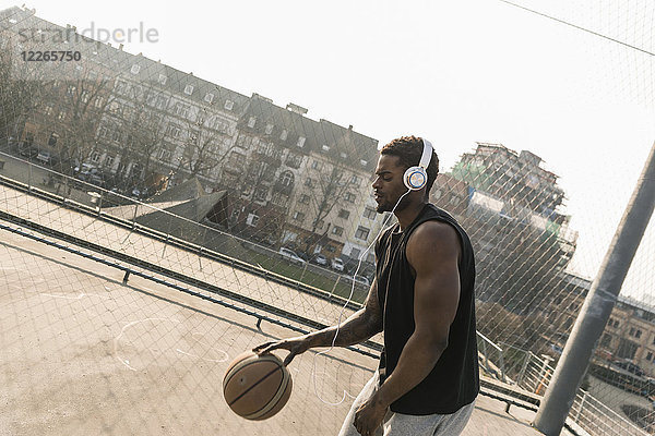 Basketballspieler mit Kopfhörer in Aktion auf dem Platz