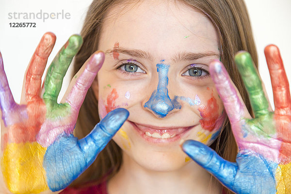 Porträt eines lächelnden Mädchens mit Fingerfarben auf den Händen