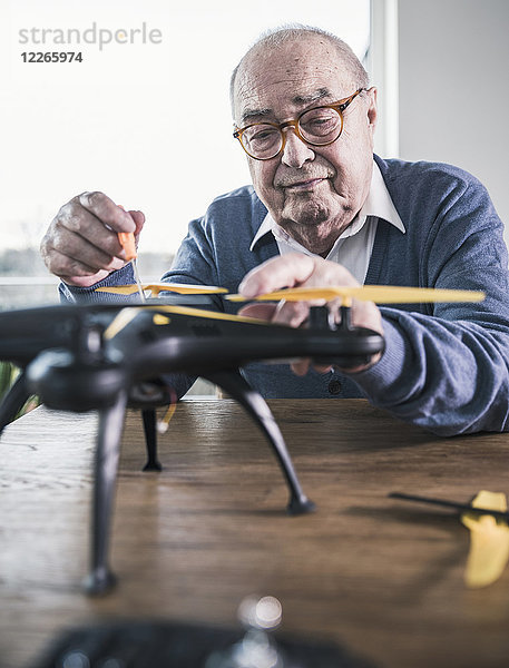 Porträt eines älteren Mannes bei der Arbeit an einer Drohne